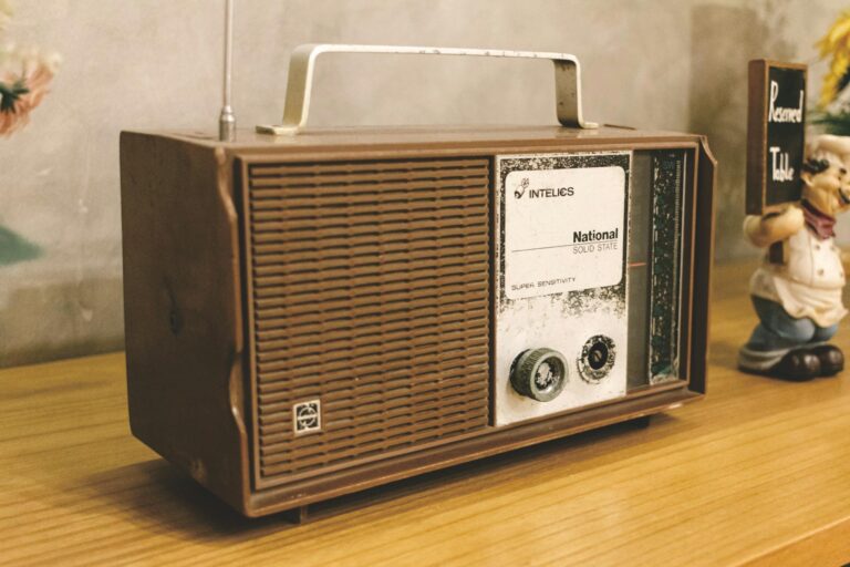 A classic vintage radio with an analogue design sitting on a wooden table indoors.